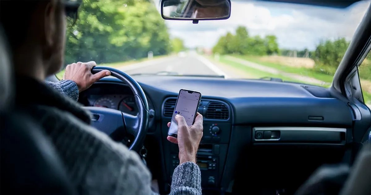 man texting and driving